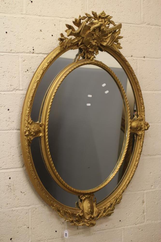 A GILT WOOD OVAL PIER GLASS Image