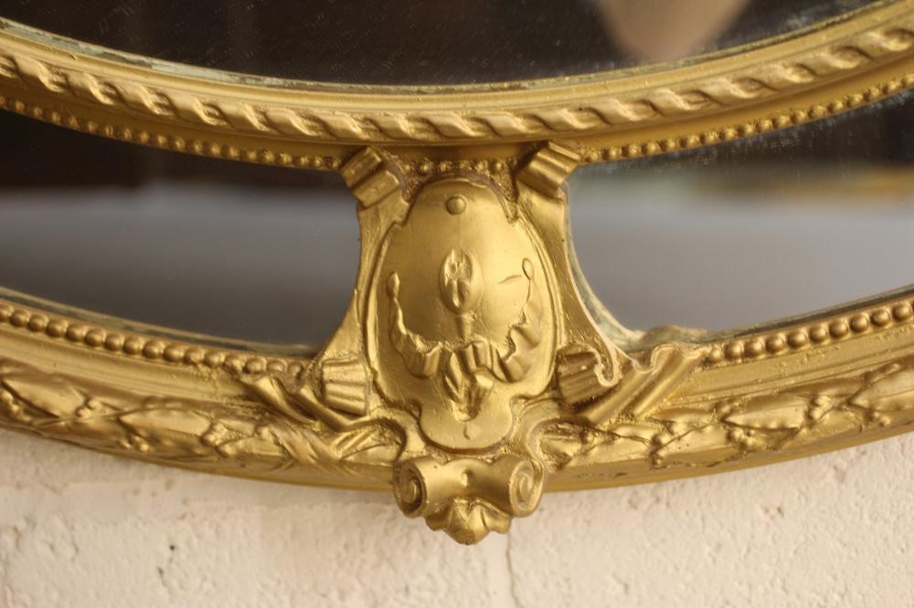 A GILT WOOD OVAL PIER GLASS Image