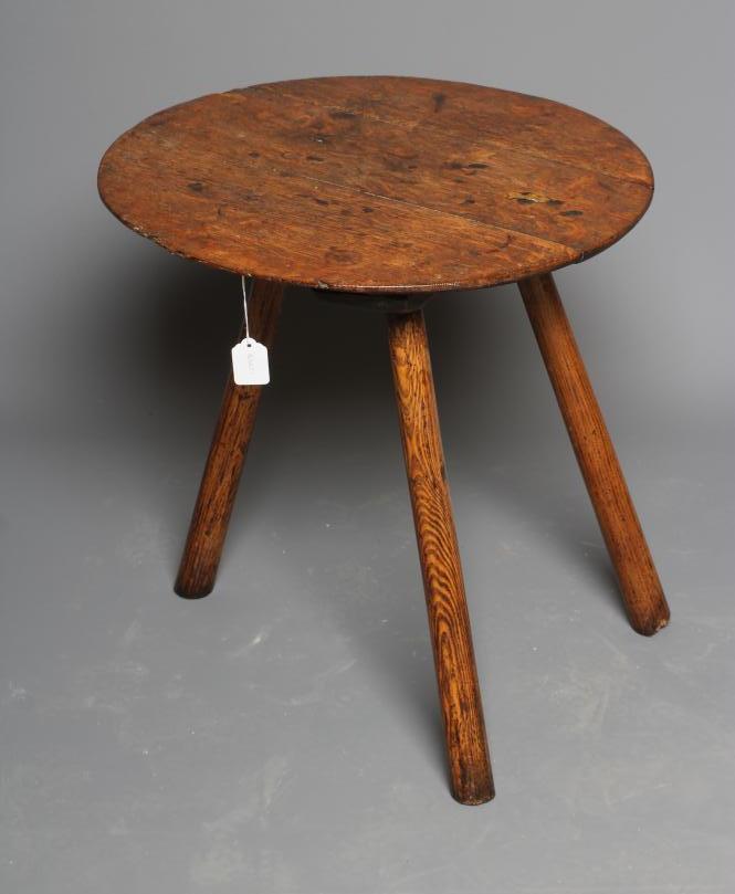 AN OAK CRICKET TABLE, 19th century, the three plank circular top with chamfered lower edge, raised Image