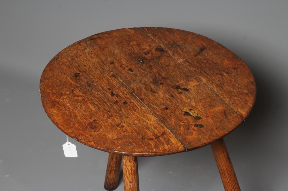 AN OAK CRICKET TABLE, 19th century, the three plank circular top with chamfered lower edge, raised Image