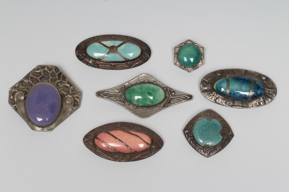 A COLLECTION OF SEVEN RUSKIN TYPE ARTS AND CRAFTS PEWTER BROOCHES Image