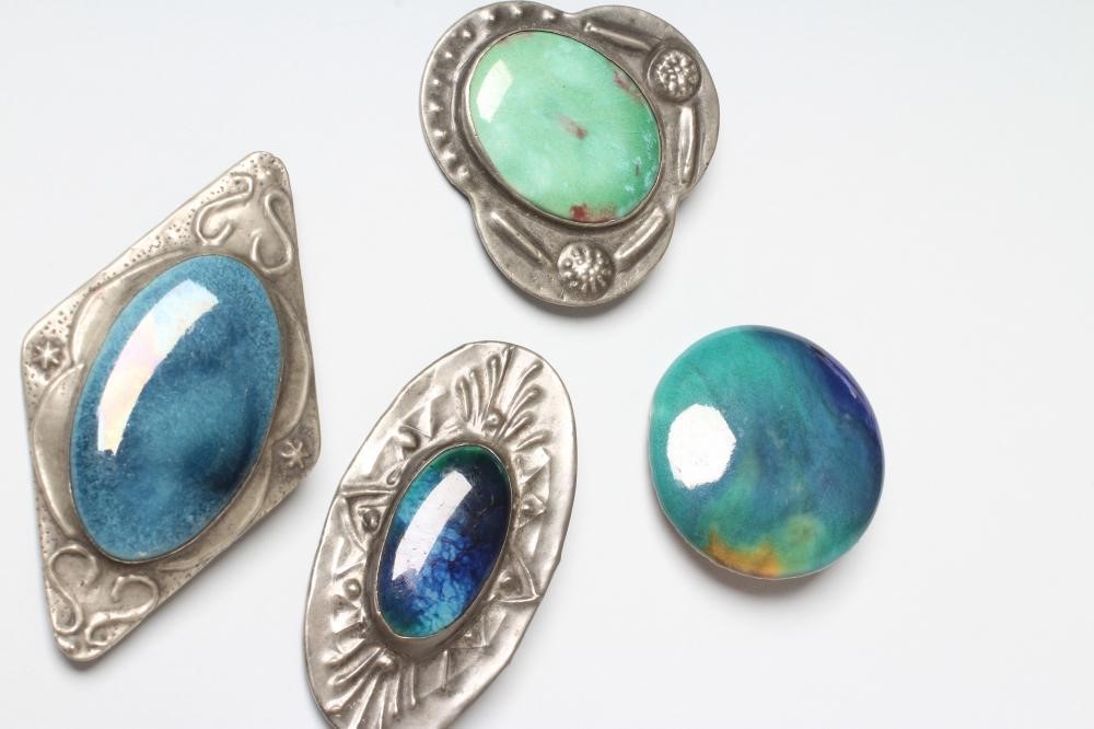 A COLLECTION OF FIVE RUSKIN TYPE ARTS AND CRAFTS PEWTER BROOCHES Image