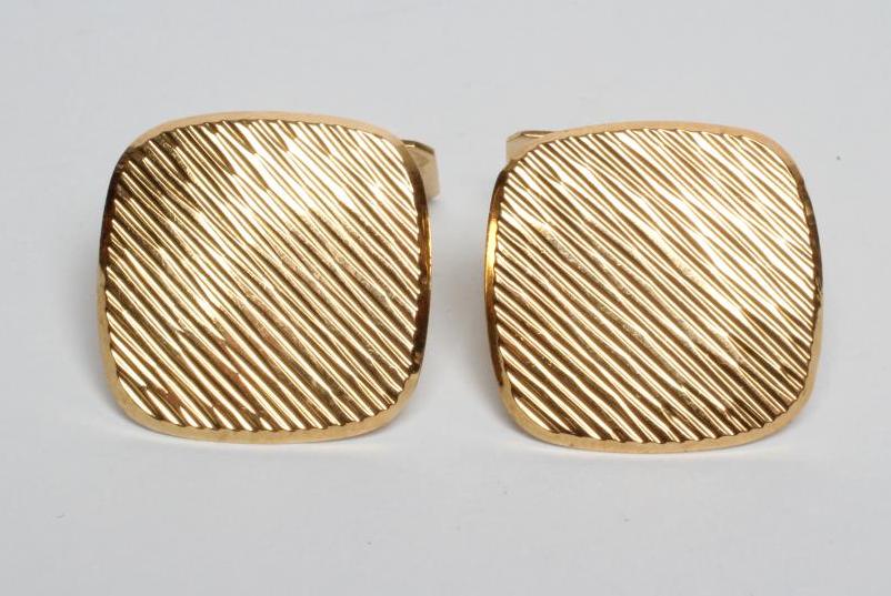 A PAIR OF MODERN CUFFLINKS of rounded square section with brushed bark effect finish and engine Image