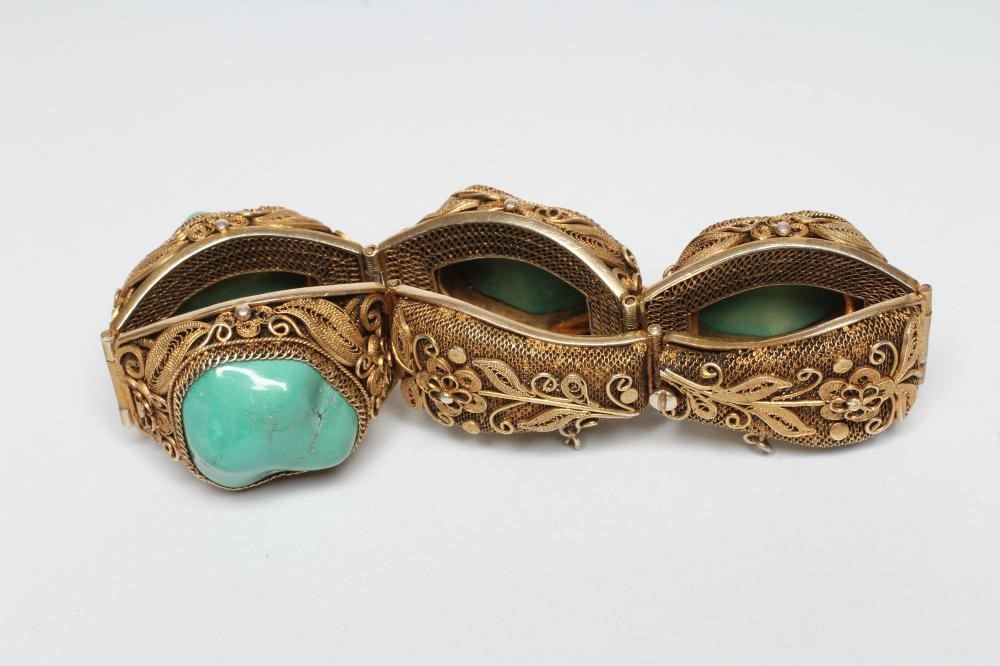 A CHINESE FILIGREE GILT BRACELET inset with four irregular polished green hardstones in cushion Image