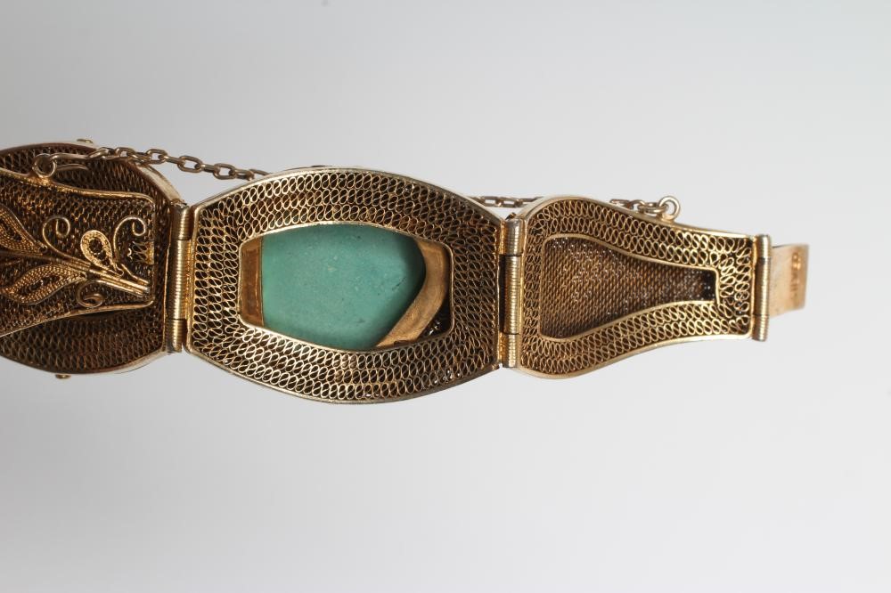A CHINESE FILIGREE GILT BRACELET inset with four irregular polished green hardstones in cushion Image