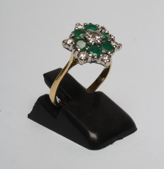A DIAMOND AND EMERALD CLUSTER RING Image