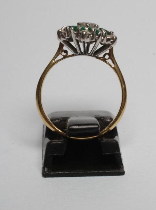 A DIAMOND AND EMERALD CLUSTER RING Image