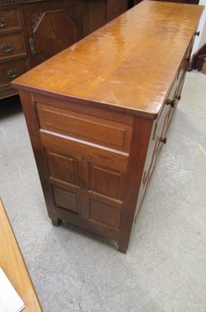 A COLIN ALMACK ADZED OAK DINING SUITE comprising multi panelled sideboard Image