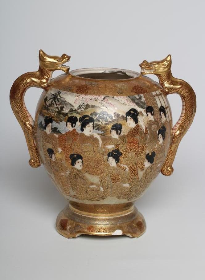 A SATSUMA EARTHENWARE VASE of rounded flared form with two dragon handles and raised upon a fixed Image