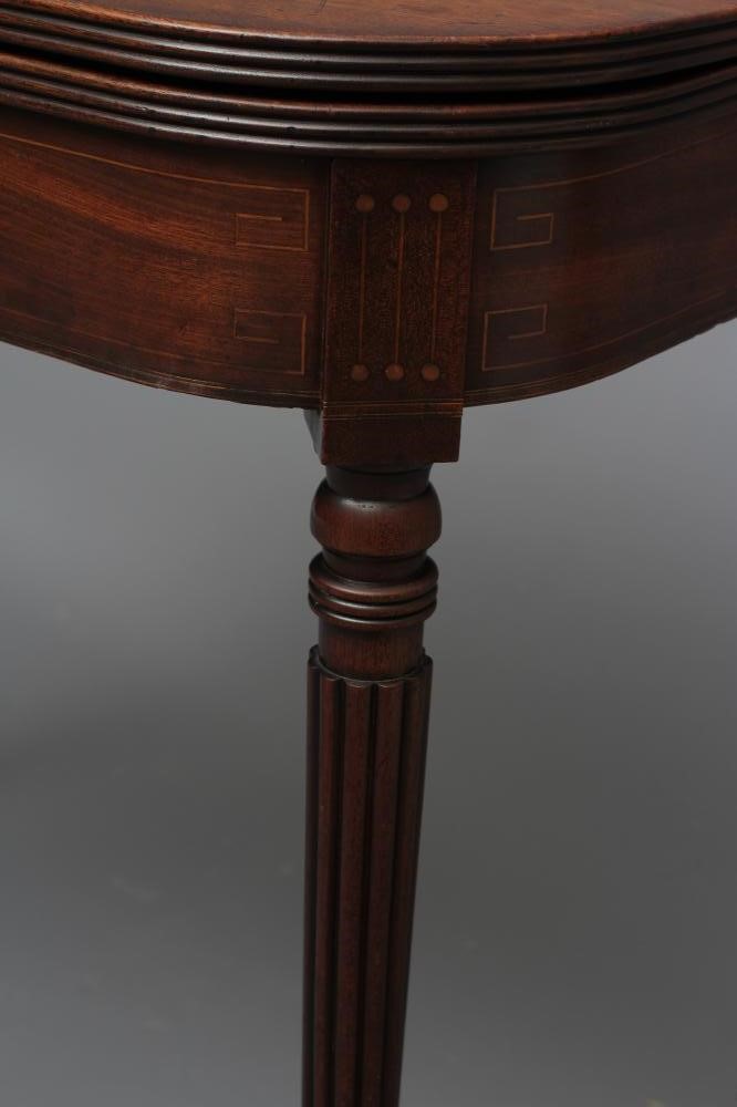 A REGENCY MAHOGANY FOLDING TEA TABLE of rounded oblong form with reeded edged top Image