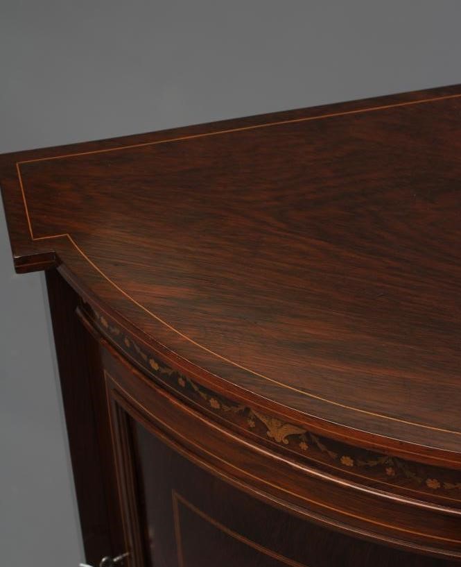 A LATE VICTORIAN ROSEWOOD AND MARQUETRY STANDING CORNER CUPBOARD of low bowed form with stringing Image