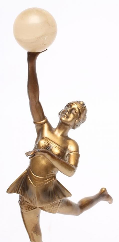AN ART DECO BRONZED SPELTER FIGURE of a young lady wearing a flared top over shorts Image