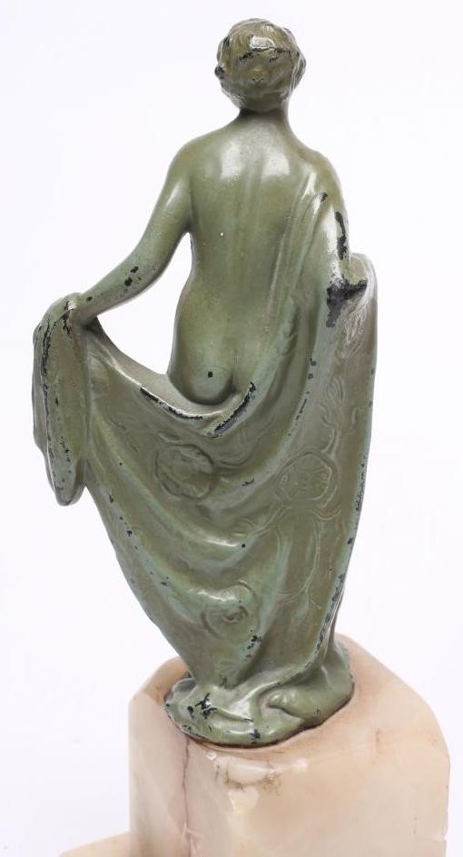 AN ART DECO BRONZED SPELTER FIGURE of a young lady wearing a flared top over shorts Image