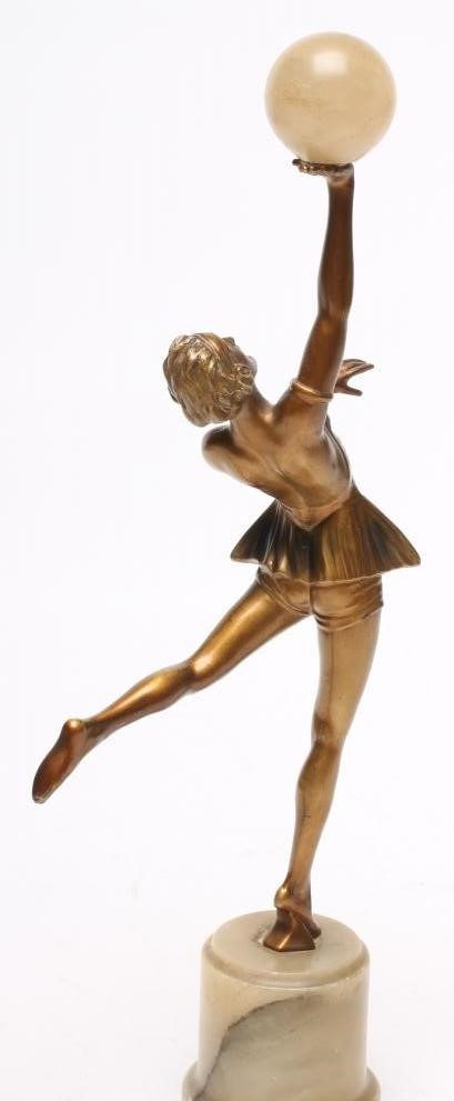 AN ART DECO BRONZED SPELTER FIGURE of a young lady wearing a flared top over shorts Image