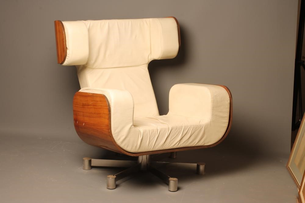 A MOULDED VENEERED ROSEWOOD ARMCHAIR with shaped cream leather cushion Image