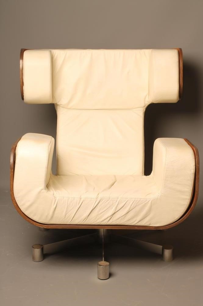 A MOULDED VENEERED ROSEWOOD ARMCHAIR with shaped cream leather cushion Image