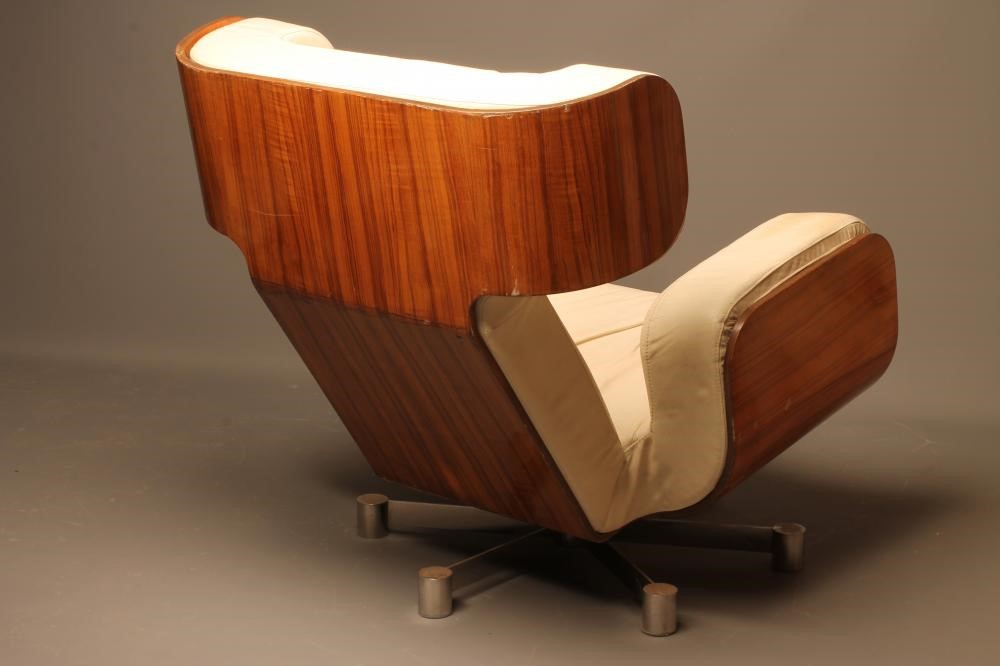 A MOULDED VENEERED ROSEWOOD ARMCHAIR with shaped cream leather cushion Image