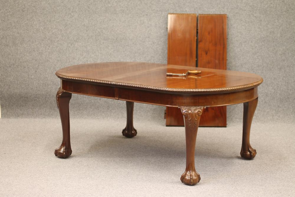 A CARVED MAHOGANY EXTENDING DINING TABLE Image