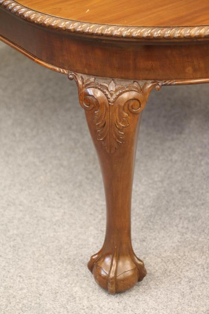 A CARVED MAHOGANY EXTENDING DINING TABLE Image