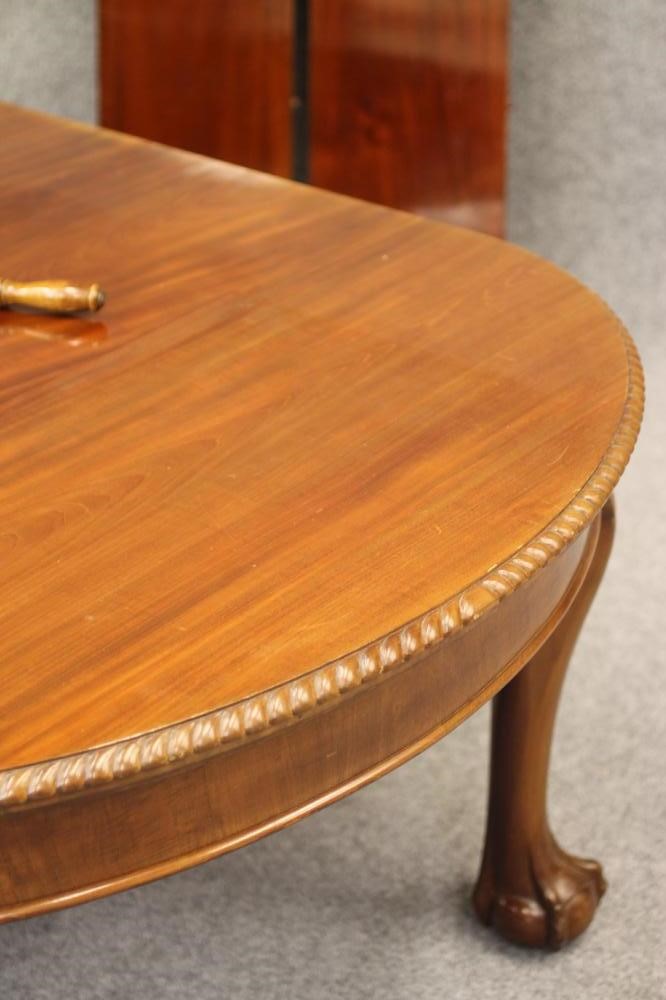 A CARVED MAHOGANY EXTENDING DINING TABLE Image