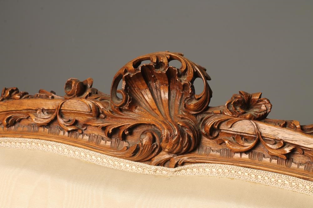 A NAPOLEON III CARVED WALNUT CANAPE upholstered in ivory silk Image
