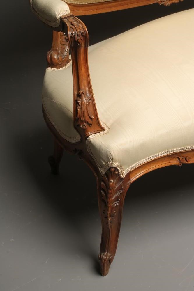 A NAPOLEON III CARVED WALNUT CANAPE upholstered in ivory silk Image