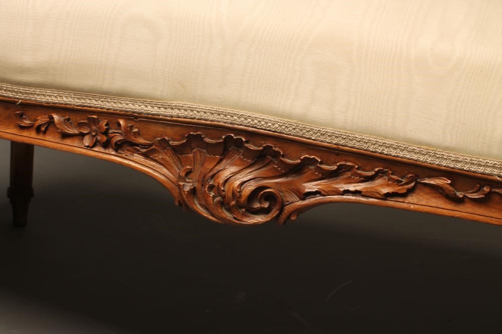 A NAPOLEON III CARVED WALNUT CANAPE upholstered in ivory silk Image