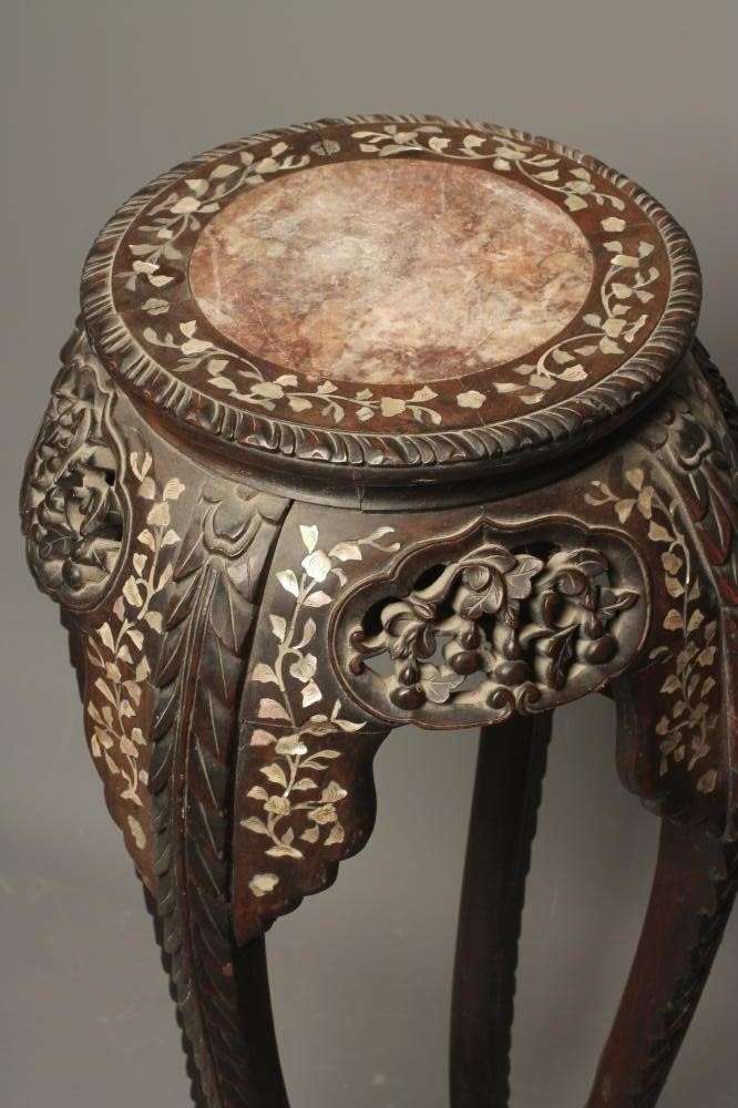 A CHINESE CARVED HARDWOOD JARDINIERE STAND of circular form inlaid with trailing foliage in mother Image