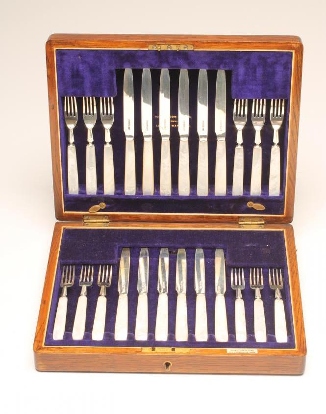 A SET OF TWELVE PAIRS OF SILVER DESSERT KNIVES AND FORKS Image