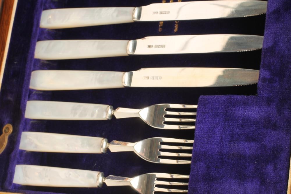 A SET OF TWELVE PAIRS OF SILVER DESSERT KNIVES AND FORKS Image