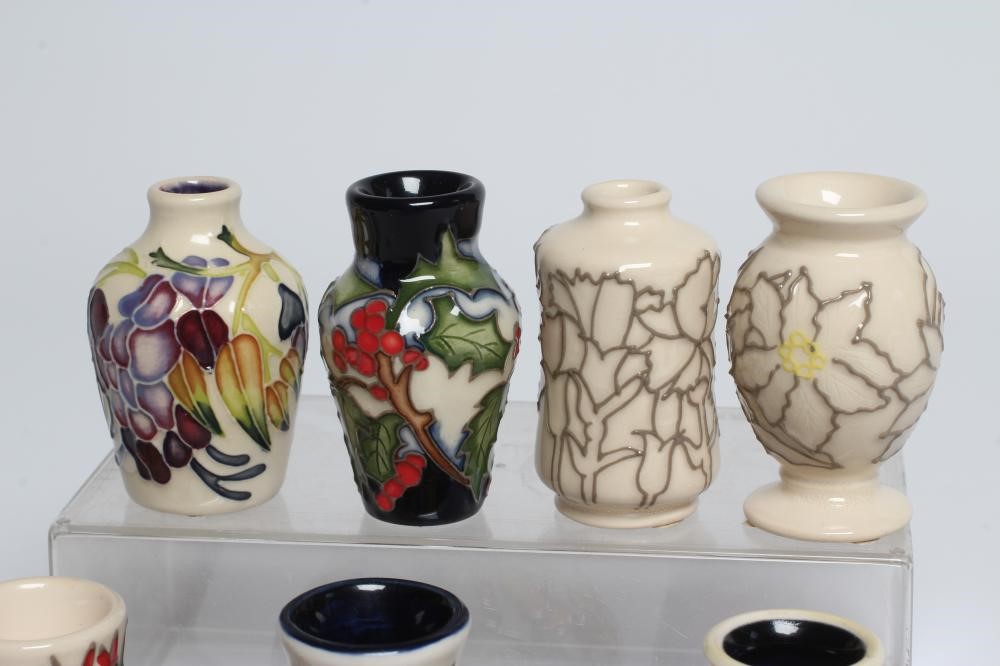 A COLLECTION OF NINE MINIATURE MOORCROFT POTTERY VASES Image