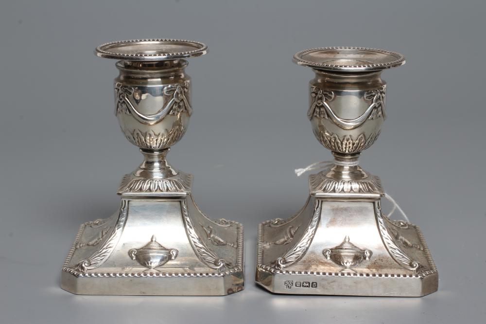 A COMPOSITE PAIR OF EDWARDIAN SILVER DWARF CANDLESTICKS Image