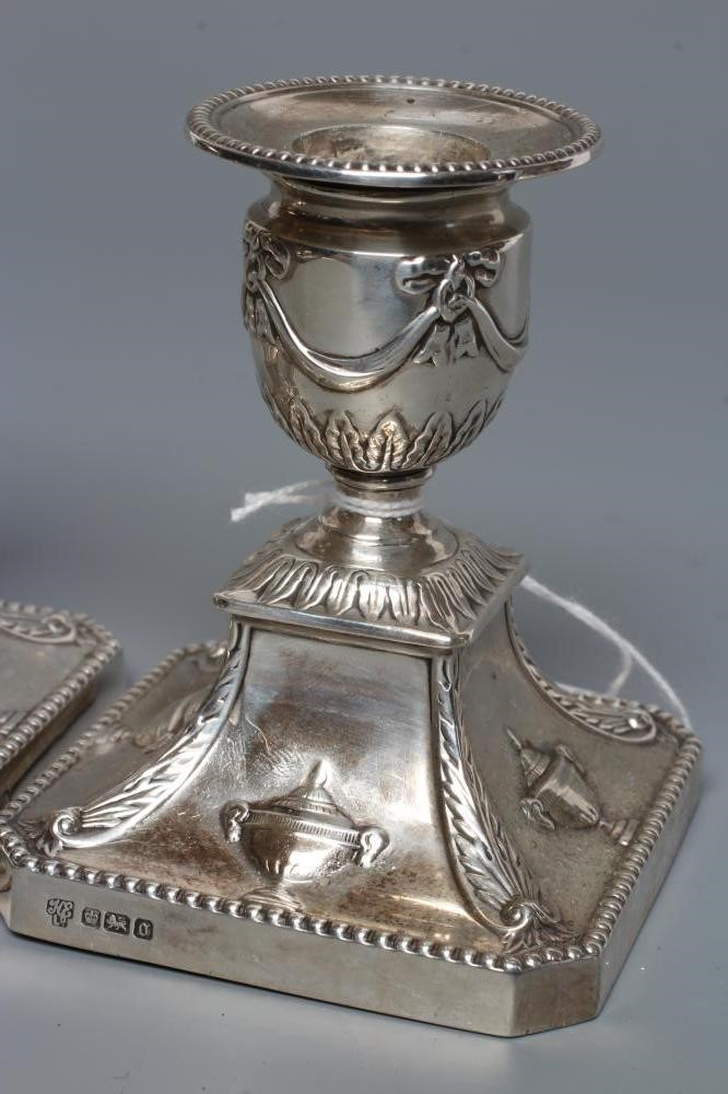 A COMPOSITE PAIR OF EDWARDIAN SILVER DWARF CANDLESTICKS Image