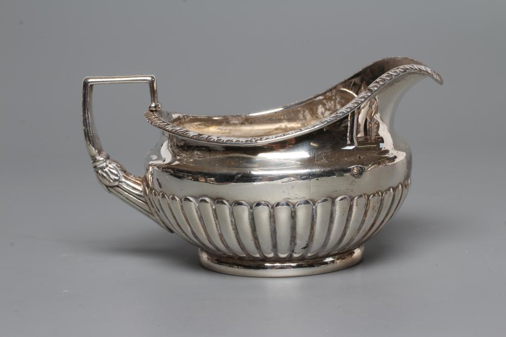 A LATE GEORGE III SILVER MILK JUG, maker Burwash and Sibley, London 1809, of semi-fluted squat Image