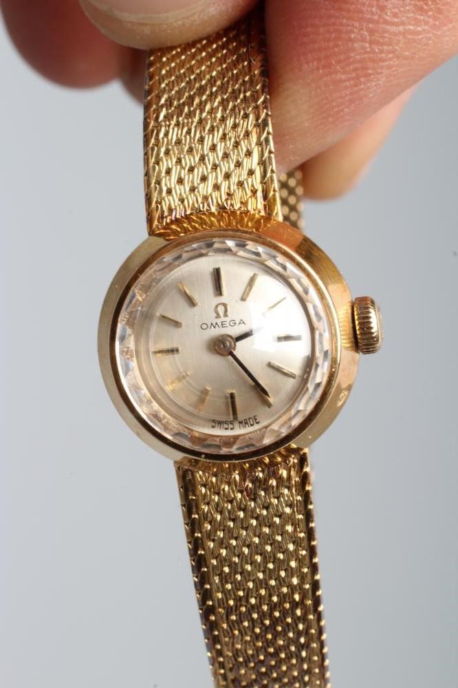 A LADY'S 14CT GOLD OMEGA WRISTWATCH, the silvered dial with gilt metal batons in a plain tapering Image