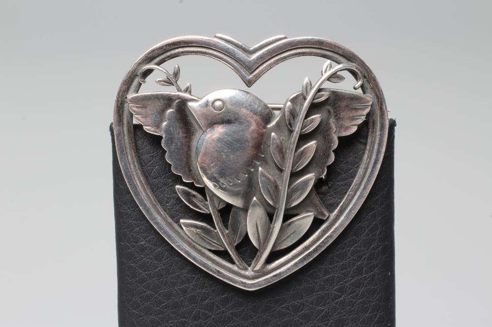 A GEORG JENSEN SILVER HEART SHAPED BROOCH designed by Arno Malinowski cast with a bird and leaves, Image