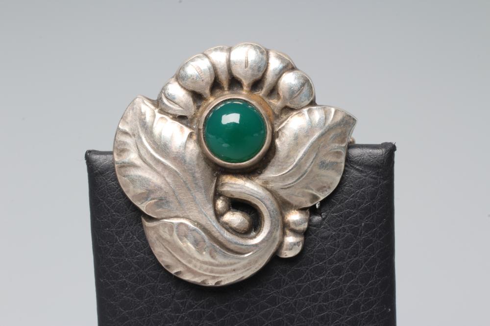 A GEORG JENSEN SILVER BROOCH similar to the previous lot inset with a circular polished green Image