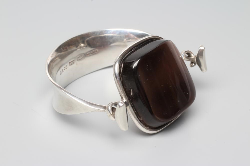A GEORG JENSEN SILVER BANGLE designed by Viviana Torun Bulow-Hube, the tension clamp centred by a Image