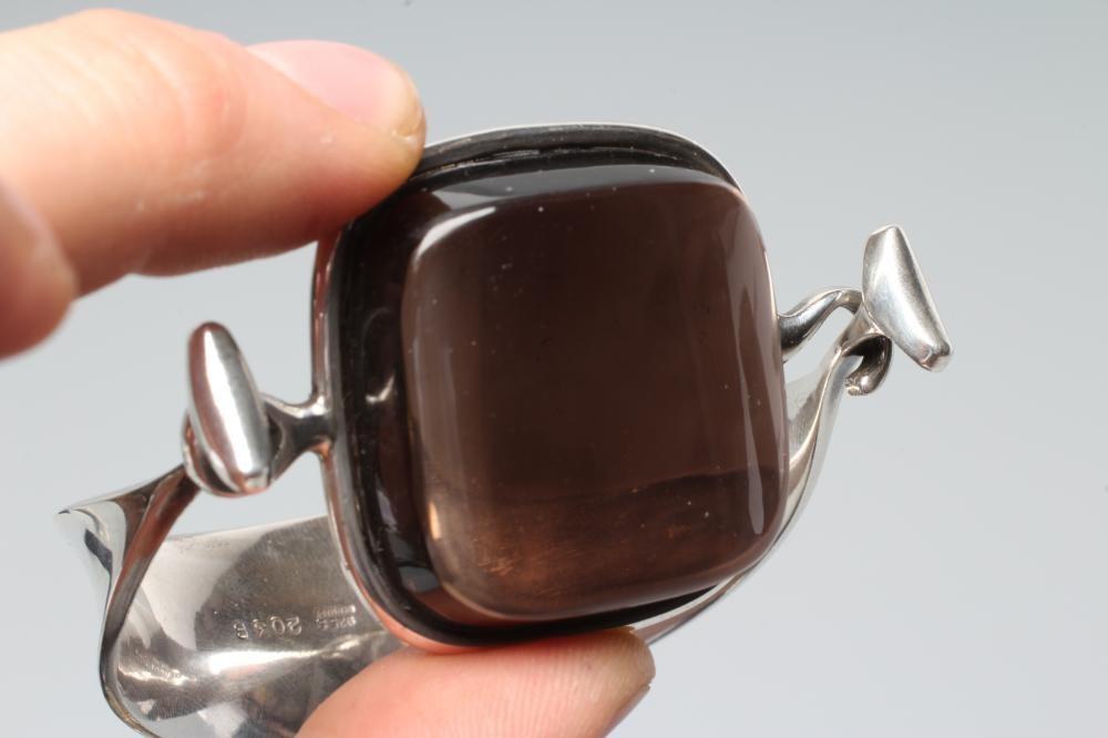 A GEORG JENSEN SILVER BANGLE designed by Viviana Torun Bulow-Hube, the tension clamp centred by a Image