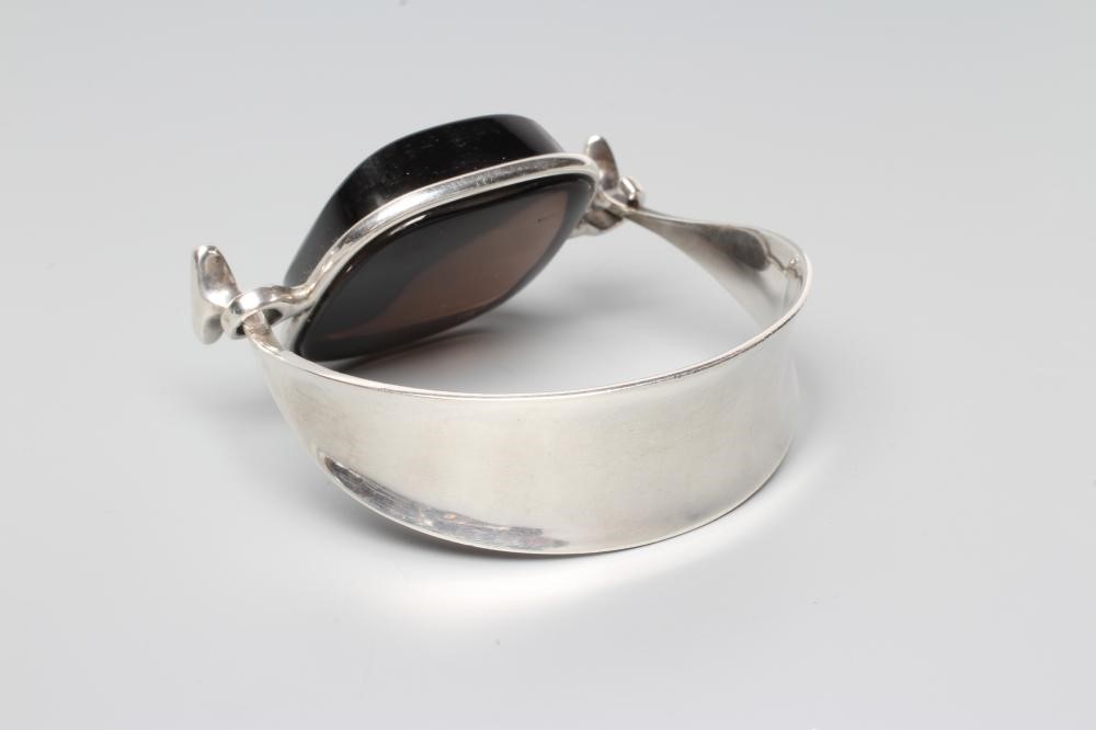 A GEORG JENSEN SILVER BANGLE designed by Viviana Torun Bulow-Hube, the tension clamp centred by a Image