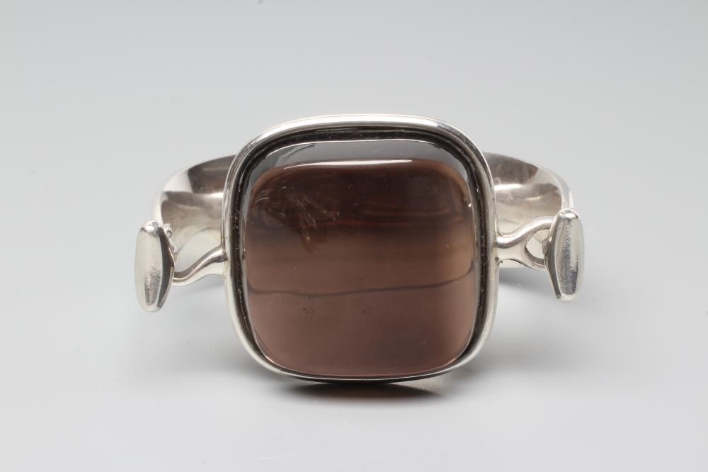 A GEORG JENSEN SILVER BANGLE designed by Viviana Torun Bulow-Hube, the tension clamp centred by a Image