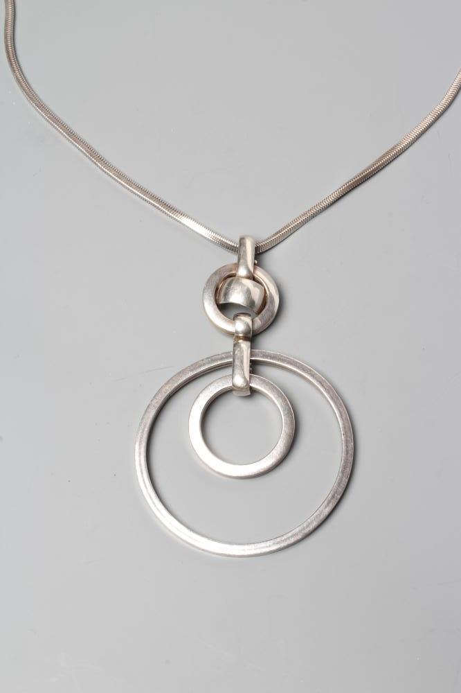 A GROSSE OF GERMANY SILVER PENDANT comprising two concentric circlets loose in mount on a fixed Image