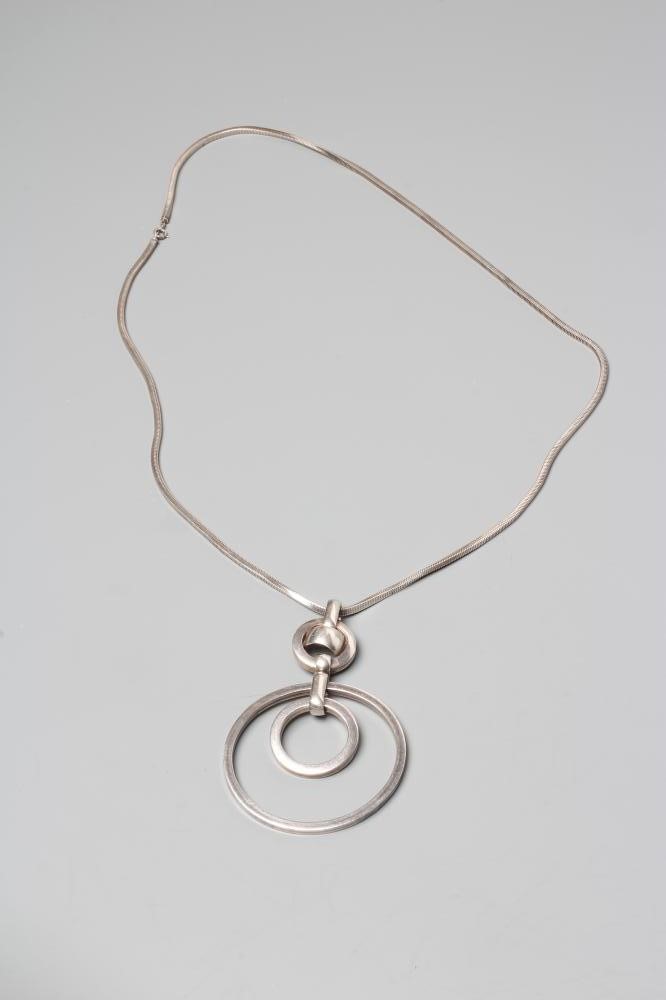 A GROSSE OF GERMANY SILVER PENDANT comprising two concentric circlets loose in mount on a fixed Image