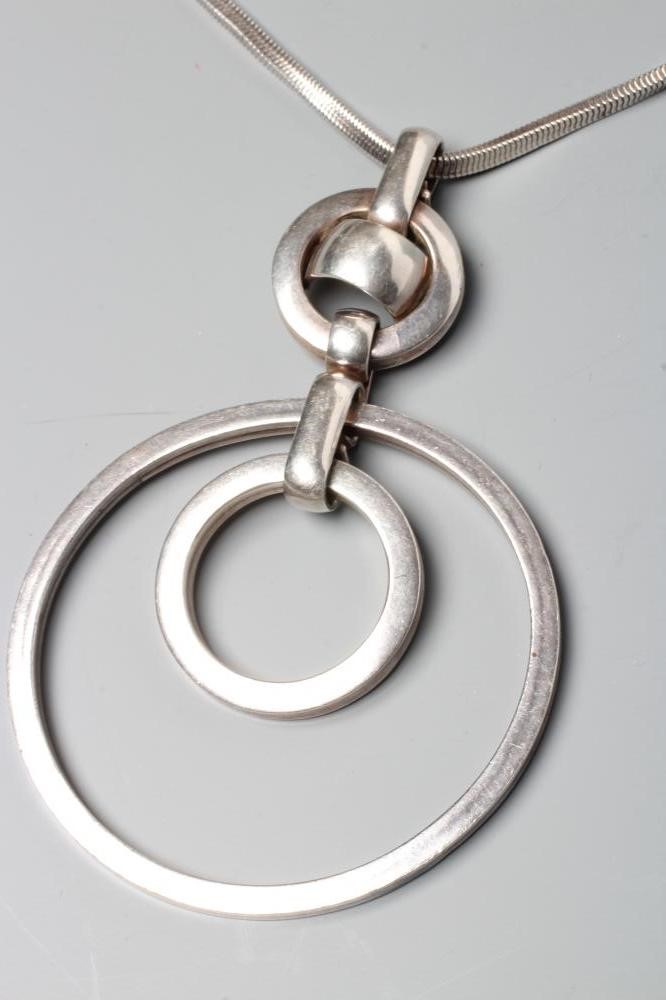 A GROSSE OF GERMANY SILVER PENDANT comprising two concentric circlets loose in mount on a fixed Image