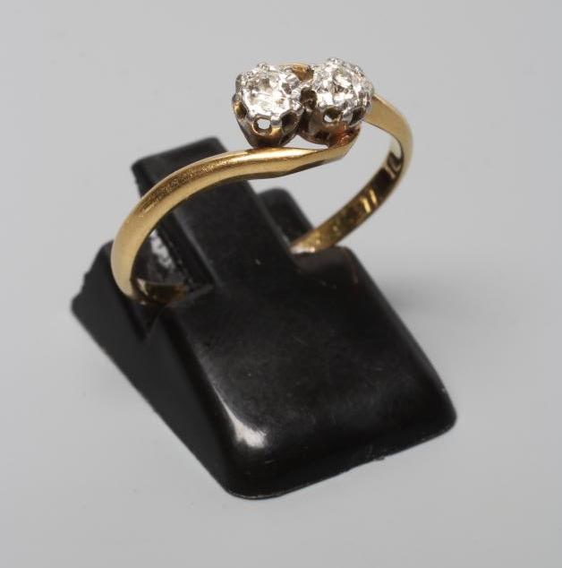 A TWO STONE DIAMOND CROSSOVER RING, the brilliant cut stones each of aproximately 0.10cts, claw set Image