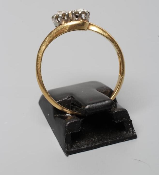 A TWO STONE DIAMOND CROSSOVER RING, the brilliant cut stones each of aproximately 0.10cts, claw set Image