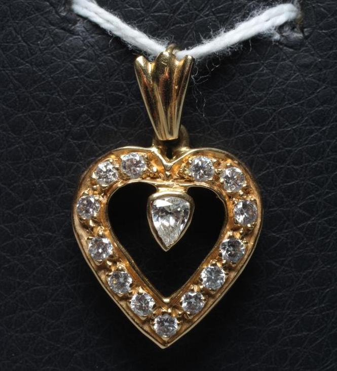 A DIAMOND HEART PENDANT, the thirteen mix cut stones point set to an open border centred by a single Image