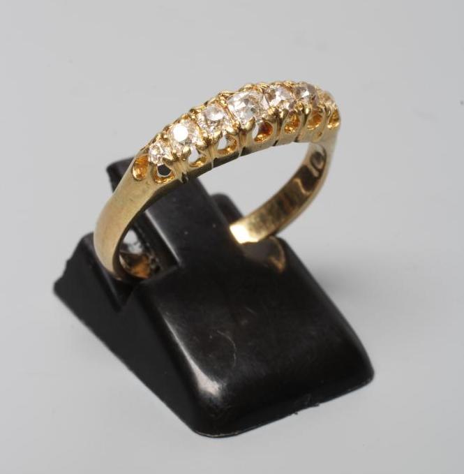 A SEVEN STONE DIAMOND HALF HOOP RING, the mix cut stones claw set to a plain shank stamped 18ct, Image