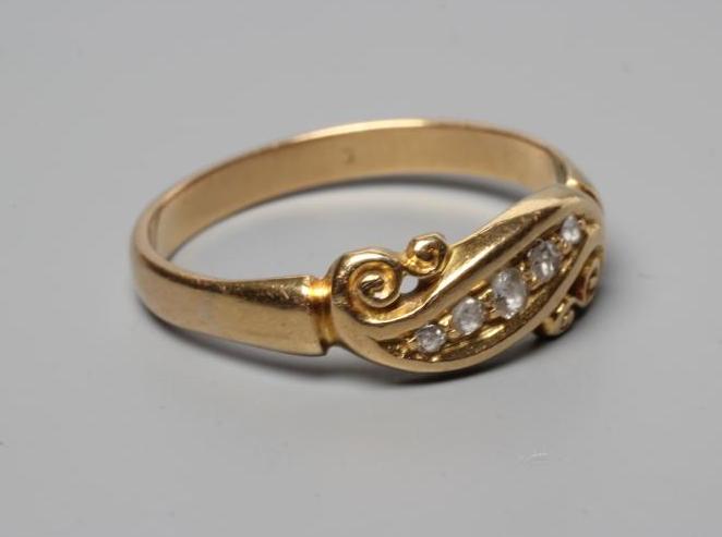 A LATE VICTORIAN DIAMOND RING, the five rose cut stones in a crossover setting with carved scroll Image