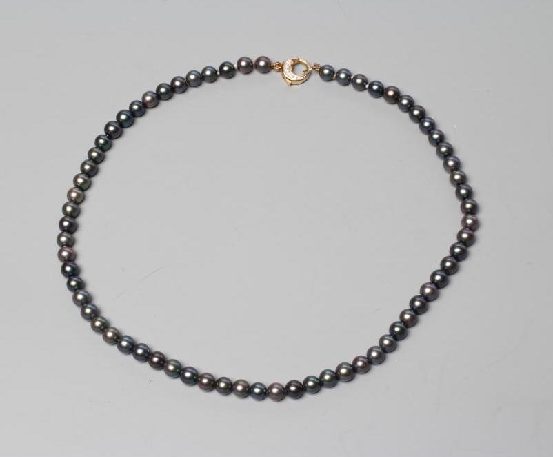 A SINGLE STRING OF BLACK CULTURED PEARLS, the circular clasp stamped 750 and point set with seven Image